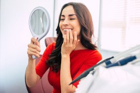 Woman smiling while looking at reflection in mirror