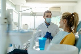 Smiling patient and dentist talking in treatment room