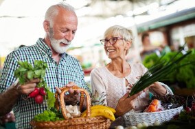 Older man and woman shopping for vegetables at the market