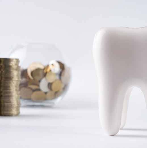 Tooth next to a pile of coins